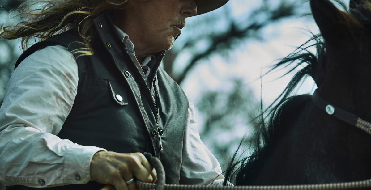 Woman riding a horse wearing a heavy weight heritage Driza-Bone vest